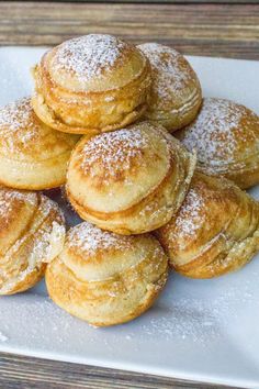 a white plate topped with powdered sugar covered pastries