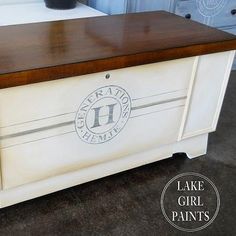 a white dresser with a wooden top and logo painted on it