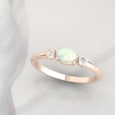 Timeless diamond and opal ring by jewelry designer Ascheron. Excellent handcrafted dainty diamond ring. Beautiful mix of brilliant cut round diamonds and smooth pear cut opal gemstone. Diamonds - 2 diamonds. Total carat weight of 0.08ct. Excellent GVS quality white diamonds. Ethically sourced. Gemstone - Real Opal, oval shape measuring 6 x 4 mm. Band - Measures 1.8 mm wide and 1.6 mm deep. Metals - Available in 14K / 18K, white, yellow or rose gold. Also in Platinum. Shipping - Free shipping to Opal Ring With Rose Cut Diamonds For Anniversary, Anniversary Opal Ring With Rose Cut Diamonds, Oval Three Stone Opal Promise Ring, Opal Diamond Ring For Anniversary, Opal And Diamond Ring For Anniversary, Diamond Opal Ring For Anniversary, Opal Gemstone Diamond Ring For Anniversary, Opal Promise Ring With Diamond Accents, Oval Three Stone Opal Ring For Anniversary