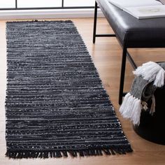 a black and white rug with fringes on the floor