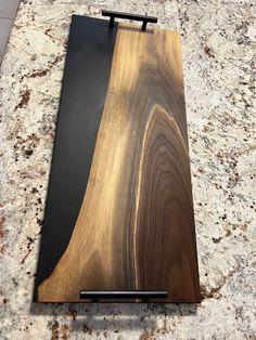 a wooden cutting board sitting on top of a granite counter next to a knife holder