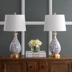 two blue and white vases sitting on top of a dresser