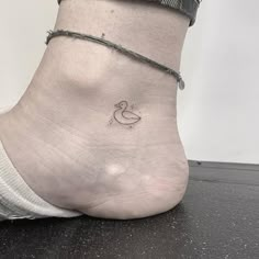 a small tattoo on the ankle of a woman's foot with a rubber duck