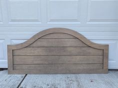 a wooden headboard sitting in front of a garage door