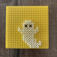 a yellow board with white circles on it and a black dot in the shape of a dog