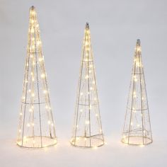 three small christmas trees with lights on them are shown in the shape of triangulars