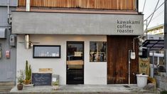 the front entrance to a coffee shop with potted plants