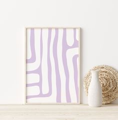 a white vase sitting on top of a wooden table next to a purple zebra print