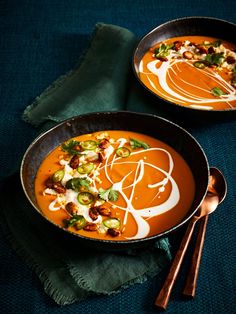 two bowls filled with soup and garnished with toppings next to each other