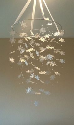 a chandelier with snowflakes hanging from it's ceiling in a room