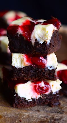 two pieces of chocolate cake with cherries and whipped cream on top are stacked together