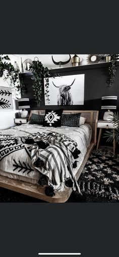 a black and white photo of a bed in a room with plants on the wall