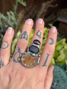 A statement ring made for a High Preistess with an Ammonite Fossil, deep black Onyx, and deep red garnet. Ammonites represent the cycles of life, leaning into the process instead of heading straight for the destination. Cycles Of Life, Ammonite Fossil, Garnet Ring, Garnet Rings, Deep Black, Red Garnet, Ring Size 7, Deep Red, Statement Ring