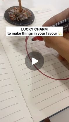 a person writing on a piece of paper with a pen in their hand and the caption lucky charm to make things in your favoir