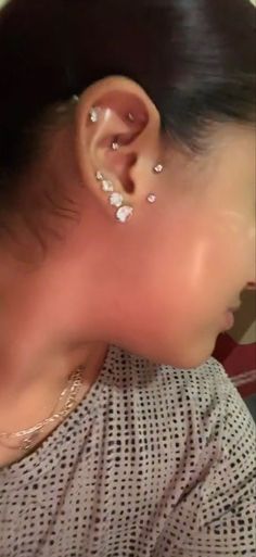 a close up of a person with ear piercings on their ears and behind them is a woman's head