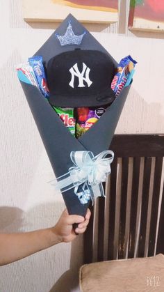 a person holding a baseball cap and candy bouquet