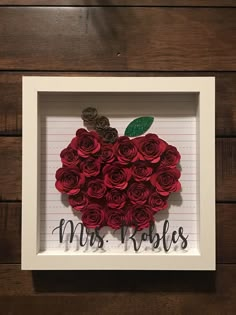 an apple made out of red roses in a white frame with the words mr and mrs written on it