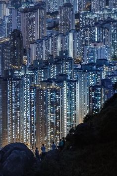 people are standing on the edge of a cliff at night in hong kong, china