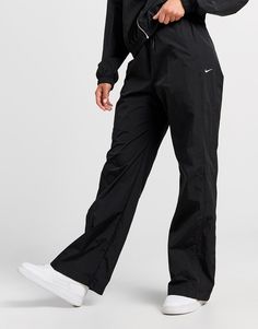 Add an essential to your rotation with these women's Woven Wide Leg Track Pants by Nike. In a Black colourway, these relaxed fit track pants are made with a water-repellent nylon fabric that provides UV protection so you can wear them whatever the weather. They feature an elastic waistband for a supportive feel, and snap pockets so you can secure your staples. Signed off with Nike branding to the leg. Machine washable. | Our model is 5'8" and wears a size small. Wide Leg Track Pants, Track Outfits, Nike React Vision, 270 Nike, Nike Branding, Leggings Hoodie, Woman Weaving, Black Nike, Nylon Fabric