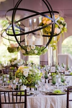 a table set up with flowers and candles for a wedding reception in a tented area