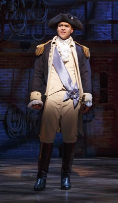 a man dressed in colonial clothing standing on stage