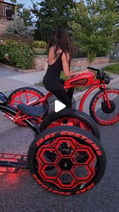 a woman riding on the back of a red and black scooter with wheels