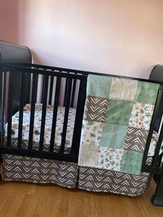 a baby crib with a quilted blanket on it