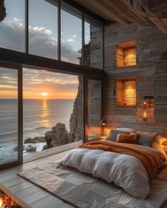 a bedroom with a large window overlooking the ocean at sunset or sunrise, is shown in this image