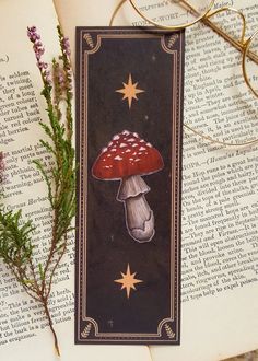 a bookmark with an image of a mushroom and stars on it next to some branches