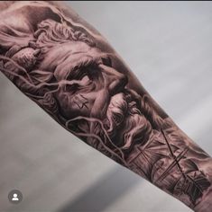 a man's arm with a black and grey tattoo on it