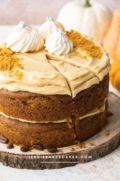 a cake with frosting and pumpkins in the background