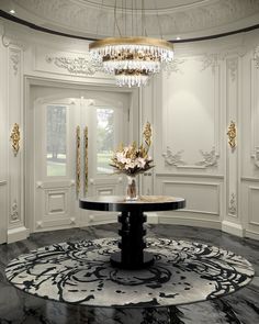 an elegant dining room with chandelier and black marble table in front of white paneled walls