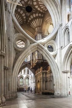 the inside of a large cathedral with stone floors and arches on both sides is shown