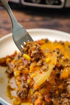 a spoon full of food on top of a white plate next to an instant pot