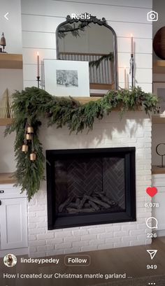 the fireplace is decorated for christmas with greenery on top and candles in front of it