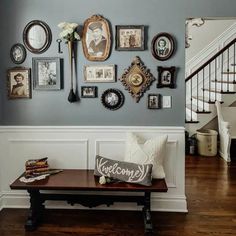 a living room with pictures on the wall and a coffee table in front of it