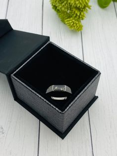 an open black box with a silver ring inside