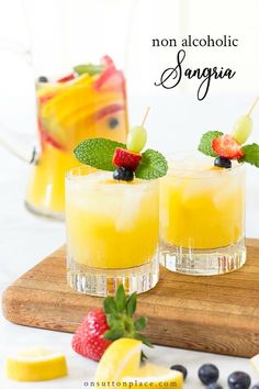 two glasses filled with fruit on top of a cutting board