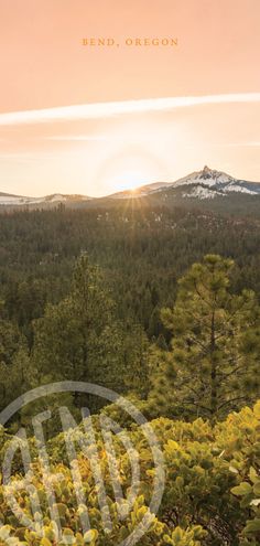 the sun is setting over some trees and mountains