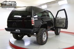 a black truck parked in a garage with its doors open and the door ajar