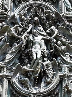 an ornate sculpture on the side of a building with angels and other people around it