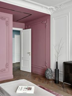 an empty room with pink walls and white trim on the door, in front of a tv