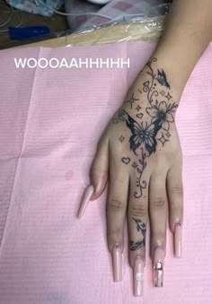 a woman's hand with a butterfly tattoo on it