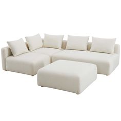 a large white couch with pillows on it and a footstool next to it