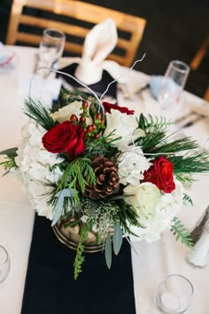 a centerpiece with white and red flowers on a table