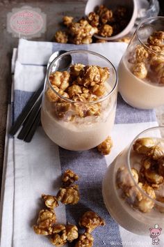 two small bowls filled with nuts on top of a table next to utensils