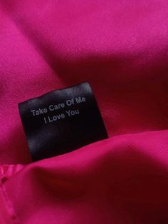 a label on a pink shirt that says take care of me i love you