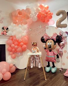 a minnie mouse birthday party with balloons and decorations