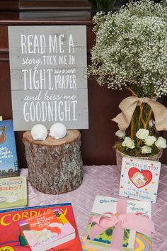 a table with books and a sign that says read me a story tuck me in tight prayer and kiss me goodnight