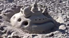 a sand castle made to look like an elephant with its head sticking out of it